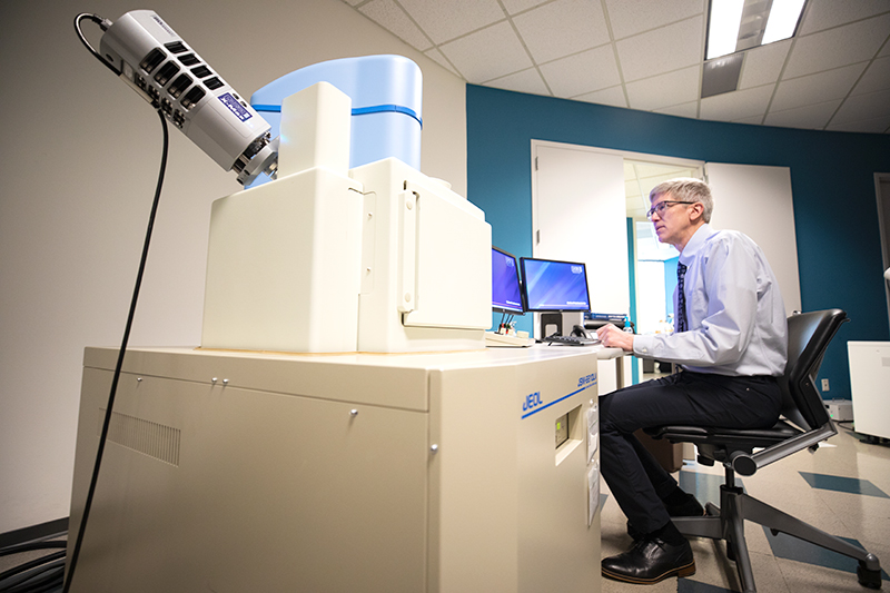 Scientist operating the JEOL 6610 scanning electron microscope